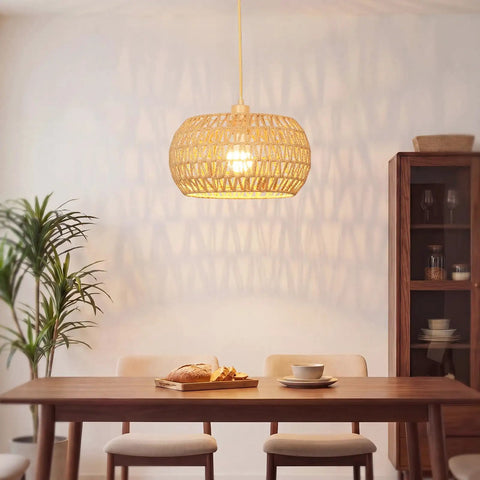 Qingmiao Boho Plug in Pendant Light with handwoven shade illuminating a dining table, 14ft cord, showcasing warm light.
