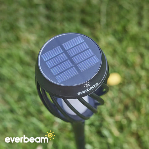 Top view of P2 Solar Flickering Flame Torch Light With Realistic Fire showing solar panel and lampshade, grass background.