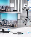 Dont Sweat The Cable Crunch With This HDMI To SDI Converter Featuring Dual SDI Outputs And Native Audio Embedding For Clean 1080P Feed connected to two monitors, showcasing a busy cityscape.
