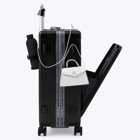 Luggage: side view of medium black aluminum-frame suitcase with white handbag attached to top handle.