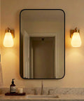 FLSNT Wall Sconces Set of 2, Hardwired E26 Wall Lighting, Modern Polished Gold Vanity Light with Frosted White Glass Shade for Bathroom, Bedroom, Hallway, Stairway, Living Room (Bulbs Not Included) beside a mirror.