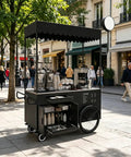 Kickass Heavy Duty Mobile Vendor Cart With Wide Shelter Canopy And Lockable Swivel Wheels Portable Black Food Display Stand on street.