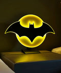 Batman Night Light Table Lamp With 3D Halo Glow, Mountable Bat Sign Wall Light on a bedside table, dimly lit room