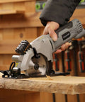 Front view of Inequalit mini circular saw, gray corded 4-Amp with 4-1/2" 24T blade and laser guide on wood