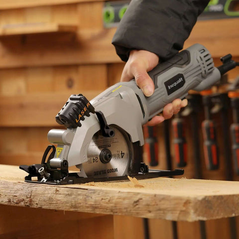 Front view of Inequalit mini circular saw, gray corded 4-Amp with 4-1/2" 24T blade and laser guide on wood