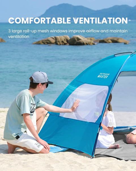 Spacious Beach Tent For Three To Four People With No Fuss Setup Sun Shade Canopy Portable UPF Fifty Plus UV Protection Removable Skylight Family Size Beach Shelter In Blue with mesh windows on a sandy beach.