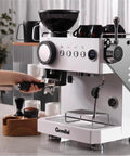 Semi Automatic Espresso Machine With Built In Grinder For Home Use Dual Mode Espresso Maker Single Or Double Shots 250g Bean Hopper Calibrated Tamping And Intuitive Guidance White on kitchen counter, portafilter in hand.