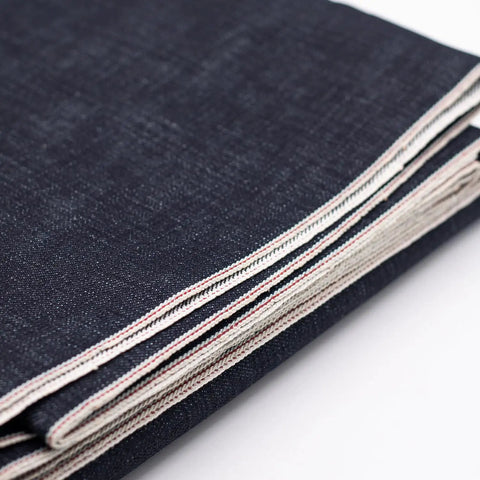 Close-up of folded 16oz Heavyweight Selvedge Denim Fabric 100 Percent Cotton Raw Indigo Shuttle Loom Woven with clean edges.