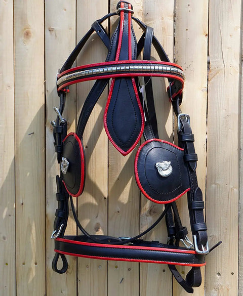 Full Size Leather Horse Driving Harness With Red Trim hanging on wooden wall, showing black leather with red edges