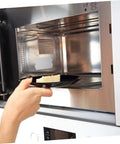Inserting food into microwave with 10 Piece Microwave Mica Insulation Sheets for easy, heat-resistant waveguide cover replacement.