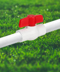 5 Pack Half Inch PVC Ball Valves For Water Shutoff, T Handle Manual On Off, installed in PVC pipe system, lush green grass background