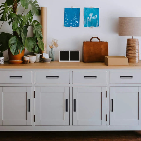 White cabinet with 60 Pack 3-3/4 Inch Square Cabinet Handles Matte Black Cabinet Pulls For Kitchen Cabinets and Drawers.