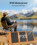 Man fishing by a lake with 30W Portable Foldable Solar Panel Charger With USB A And USB C Fast Charging, IPX5 Waterproof for Camping.