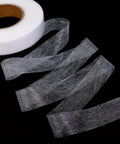 One Roll No Sew Hemming Tape With Heat Fusible Bonding, Double Sided Tape for Clothing Hemming, seen unrolled on black background
