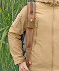 Person holding Canvas Leather Rifle Sling With 14 Shell Slots For 22 Caliber Ammunition Storage on shoulder outdoors