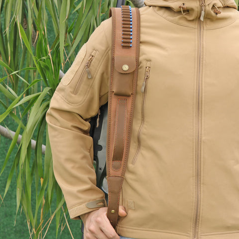 Person holding Canvas Leather Rifle Sling With 14 Shell Slots For 22 Caliber Ammunition Storage on shoulder outdoors