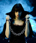 Woman with Halloween Plastic Wrist Shackles Handcuffs With Chain Links For Cosplay And Party Decor, Realistic Black 35 Inch Prop Accessory in spooky backdrop