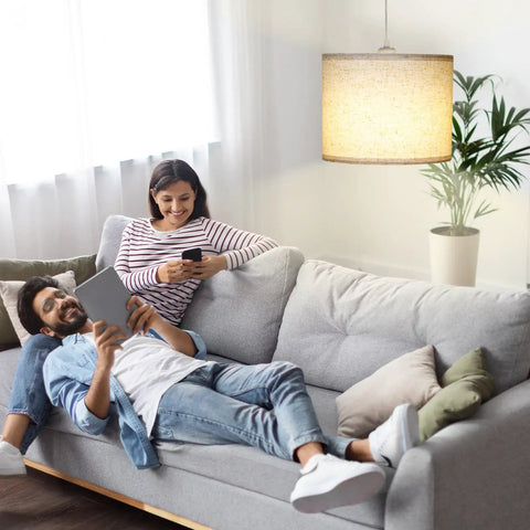 Slick Adjustable Plug In Pendant Light With Authentic Beige Linen Shade illuminates cozy living room with couple on sofa.