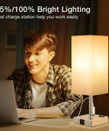 Beige Set of 2 Must-Have Touch Bedside Lamps With USB Ports and AC Outlets next to a person using a laptop at night.