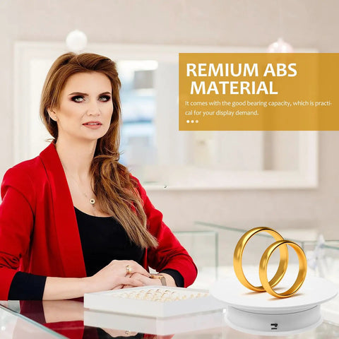 Must Have Electric Rotating Display Turntable With 360 Degree Spin, Auto Speed Control, And Suede Base showcased with rings at a jewelry shop.
