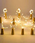 Wine Bottle Cork Lights With 12 LED Fairy String Lights Waterproof Battery Operated 10 Pack arranged to spell 'LOVE' in warm white.