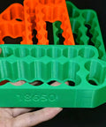 Green ergonomic holder for 18650 battery cells, featuring multiple slots for secure placement in DIY projects.