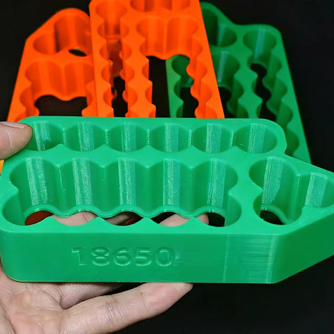 Green ergonomic holder for 18650 battery cells, featuring multiple slots for secure placement in DIY projects.