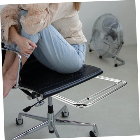Robust Stainless Steel Retractable Office Chair Footrest Smooth Flip Down Leg Rest Solid Leg and Knee Support Pro Grade Desk Grind Setup Fast Lift Out Platform with a user seated, showing the black seat and stainless steel footrest.