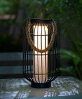 Big Solar Powered Lantern for Outdoor Use Heavy Duty Metal Hanging Lights on table with warm glow, iron frame, rattan handle