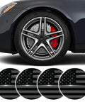 4 Piece 56 Mm US Flag Wheel Center Caps 3D Black Metal Rim Hub Covers displayed on a car wheel with red brake calipers.