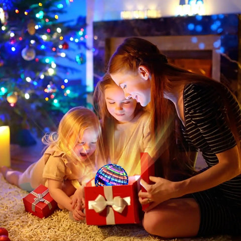 Children opening gift box to reveal Flying Orb Ball With Dazzling Lights And Hover Spinner Boomerang Drone Toy for festive fun.