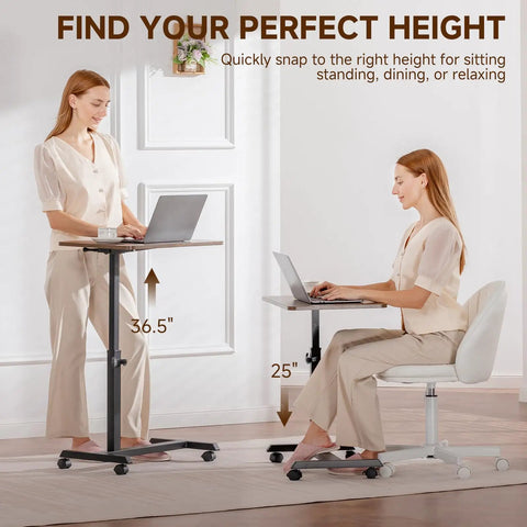 Compact Standing Desk On Wheels With Foldable 24 Inch Desktop Lockable Casters Adjustable Height From 25 To 36.5 Inches Ideal Overbed Or Home Office Laptop Table In Walnut Finish used by a woman standing and a woman seated, adjusting desk height.