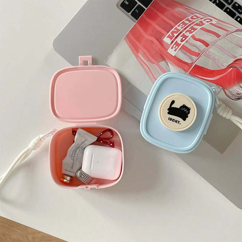 Badass Hella Tough Shockproof EDC Case For Bluetooth Headphones open, pink and blue, showcasing earbuds and accessories inside.