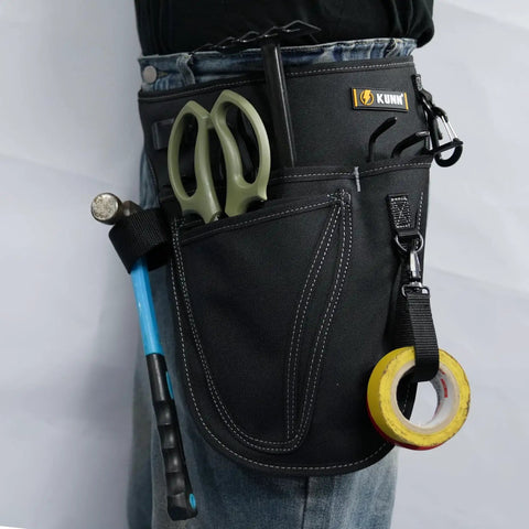 Person wearing Garden Tool Organizer Belt With Four Pockets Multi Purpose Work Apron Pouch For Gardening Florists DIY Projects And Light Plumbing Heavy Duty Tool Carrier In Black, with tools inside pockets.