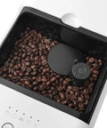 Real Deal Fully Automatic Espresso Machine With Durable Steel Burr Grinder For Bold Whole Bean Coffee And No Fuss Brewing In Sleek Matte White Kitchen Essentials showing coffee beans in grinder.