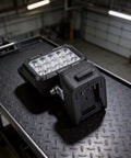 ABS Flood Light 15 LEDs Compatible with 18V Li-Ion Packs on a textured surface, showcasing its robust design and compatibility.