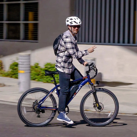 Person riding an Electric Mountain Bike For Adults With 1000W Peak Motor And 20 MPH Top Speed, 40 Mile Range on a city street.