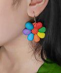 Colorful flower-shaped earrings made from Polymer Clay Starter Kit With 60 Colors For Kids And Artists, worn on ear.