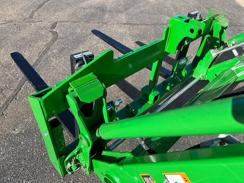 Close-up view of No Hassle Dual Mount Tractor Pallet Forks For Front Loader And Three Point Hitch in bright green finish.