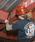 Worker using Round Three Quarter Inch Thirty Inch Connecting Bar With Fifteen Degree Angled Chisel End For Easy Alignment Prying And Chiseling Made In USA Sleever Bar to align steel beams.