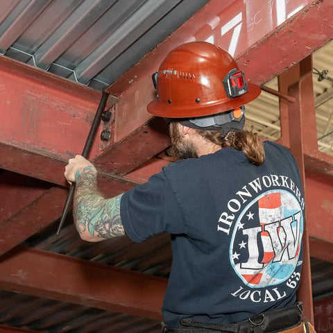Worker using Round Three Quarter Inch Thirty Inch Connecting Bar With Fifteen Degree Angled Chisel End For Easy Alignment Prying And Chiseling Made In USA Sleever Bar to align steel beams.