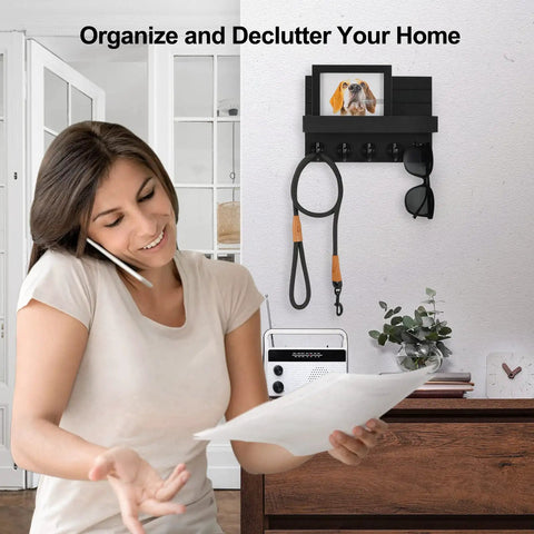 Woman organizing papers next to wall mounted key holder with shelf and large hooks for keys bags coats umbrellas and mail paulownia wood entryway organizer