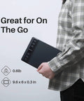 Compact Drawing Tablet With Slick Scroll Wheel And Ergonomic Stylus Delivering Sick Precision And Butter Smooth Pressure Response Perfect For Pc Artists Seeking Zero Lag Creativity And Hassle Free Setup In Sleek Black being held for portability.