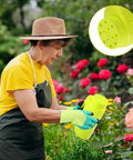 Gardener using Handheld Lawn Spreader Kit For Grass Seed Fertilizer Ice Melt And Sand Includes Scoop And Gloves Portable Yard Spreader With Adjustable Flow And Twelve Hole Settings Two Liter Capacity Green in a rose garden