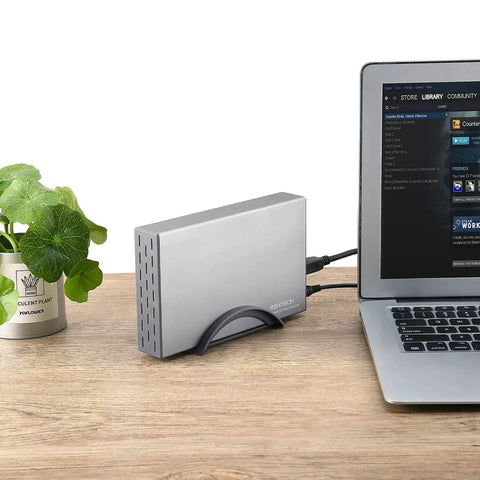 Beefy Aluminum 3.5 Inch Hard Drive Enclosure With Hassle Free USB 3.0 To Sata Docking, connected to a laptop on wooden table.