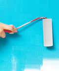 Hand using a white mini sponge roller for walls, part of the Twelve Pack Nifty Little Mini Sponge Rollers With Cushioned Handles For Walls And Detail Work Gives You A Straight Up Flawless Coat Every Time Super Simple Cleanup Built Solid For Daily Hustle.