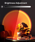 Sunset Lamp With Remote And 360 Degree Rotation projecting multicolor light on a plant and wall, brightness adjustment shown.