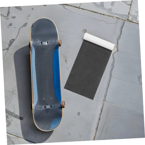 Two Pack Black PVC Grip Tape Sheets For Skateboard And Scooter Decks Weatherproof No Slip Traction Tape next to skateboard
