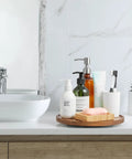 Bathroom scene with 10 Inch Acacia Wood Lazy Susan Turntable Organizer For Cabinet Round Serving Tray on countertop holding toiletries