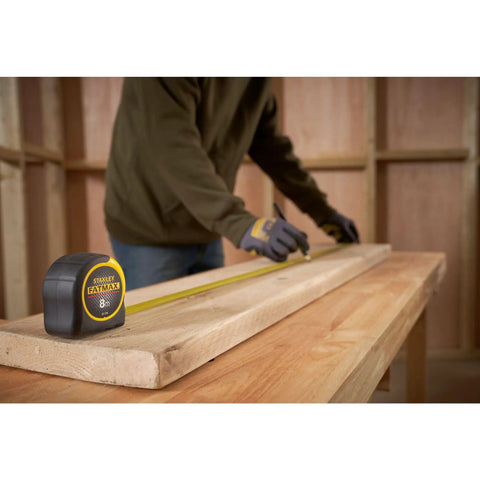 Man using Tape Measure With Blade Armor Built Tough 8 M Metric, Shock Resistant, Mylar Coating, Cushion Grip, Wide 32mm Blade, 3.35 M Standout, Class II Accuracy, Model 0-33-728 on wooden plank
